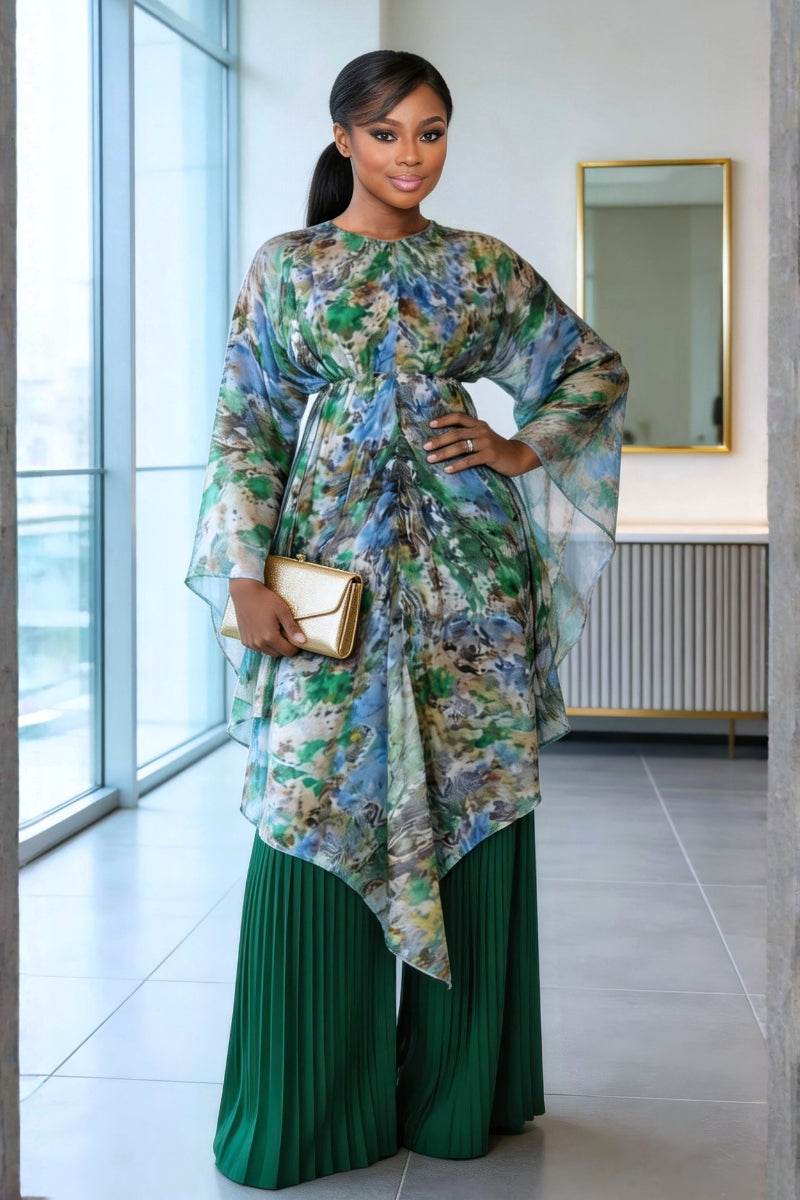 Woman wearing a floral top and green pants in a modern interior setting