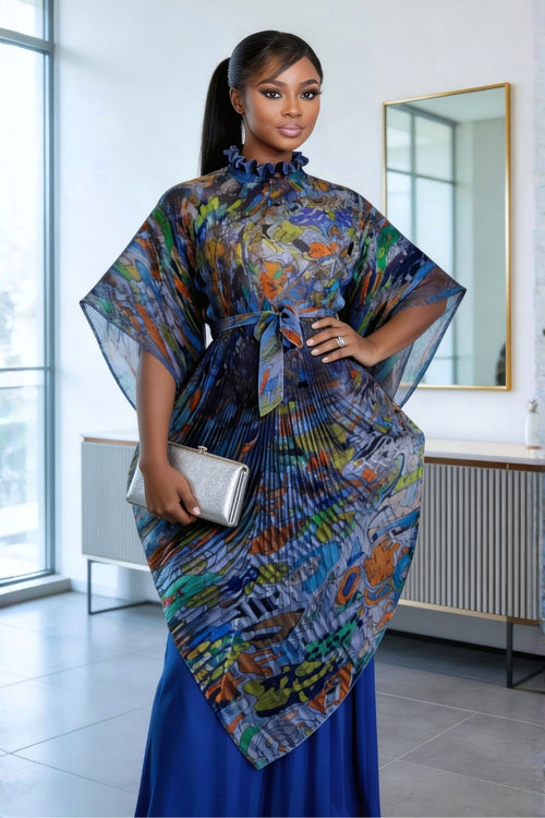 Woman wearing a colorful dress with sheer sleeves in an indoor setting.