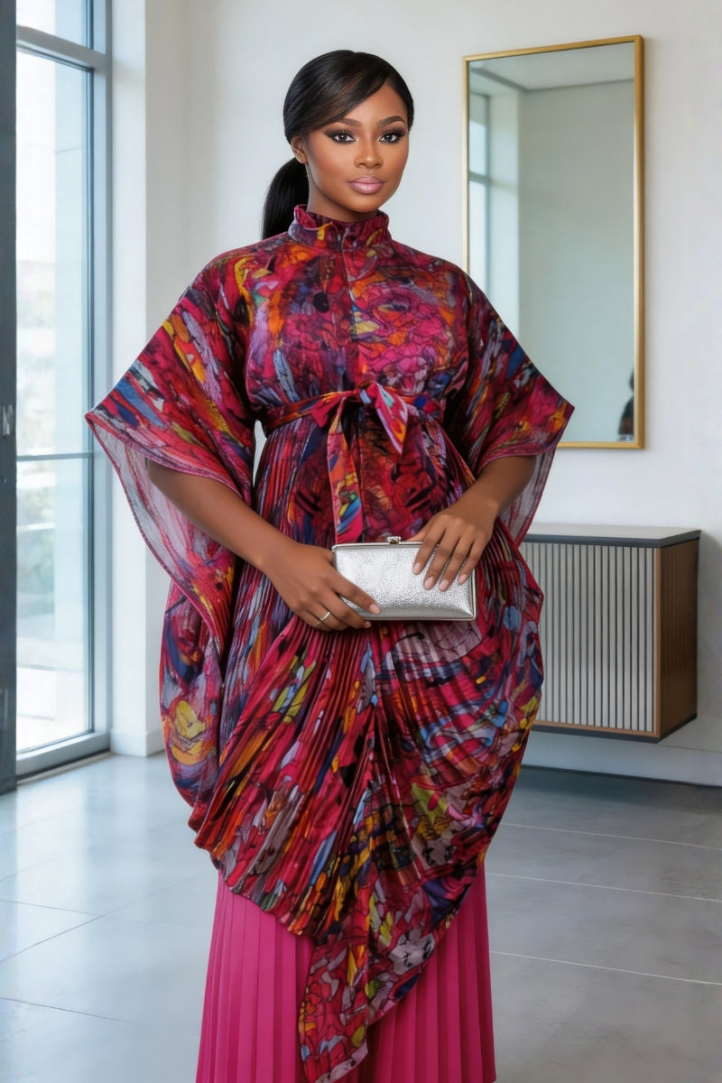 Woman wearing a colorful dress with a pink bottom half, standing indoors.