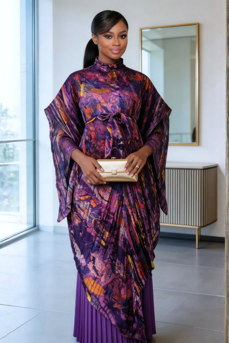 Woman in a vibrant, patterned dress standing in a modern interior setting.