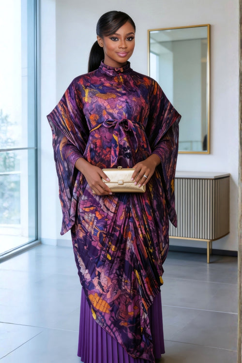Woman in a vibrant, patterned dress standing in a modern interior setting.